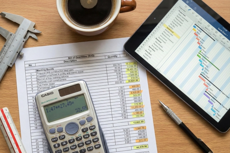 Detailed Bill of Quantities (BoQ) document and S-Curve project schedule on a desk.